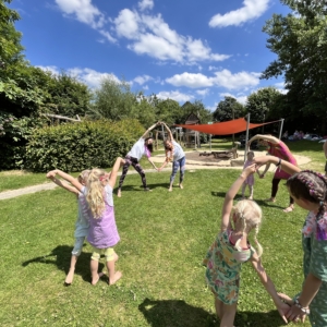 Kinder und Erwachsene mache gemeinsam Yoga im Freien