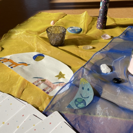 Mitte einer Kinderyogatunde mit Einhornbild, Kerze und Prisma.